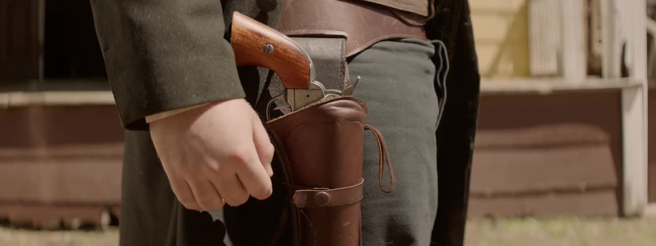A person moves their coat revealing a pistol