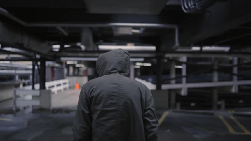 A man pulls a jacket hood over his head