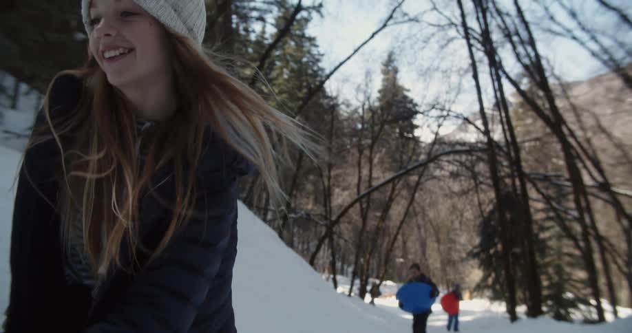 A woman smiles while leading children in the snow