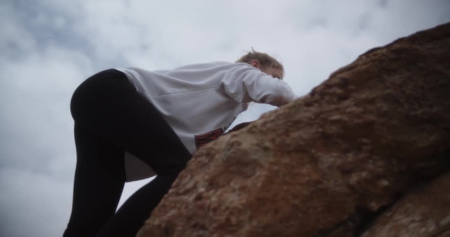 A girl climbs a rock