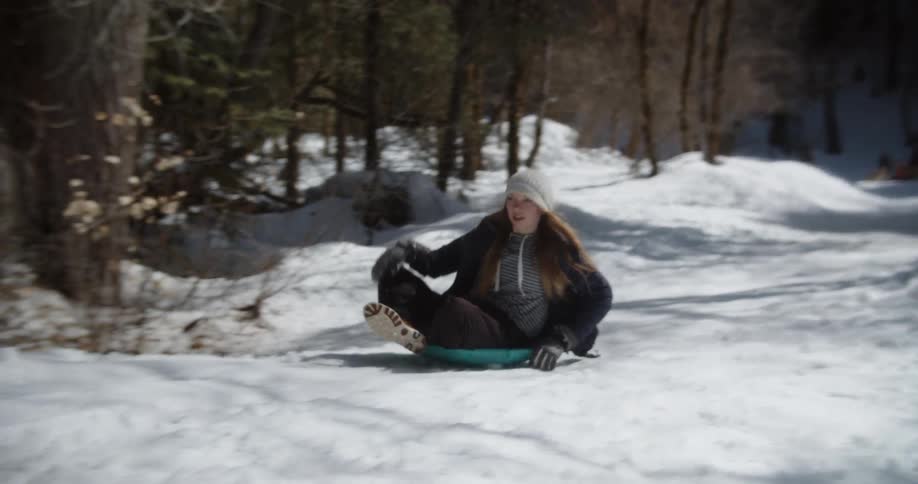 A girl rides a sled in snow