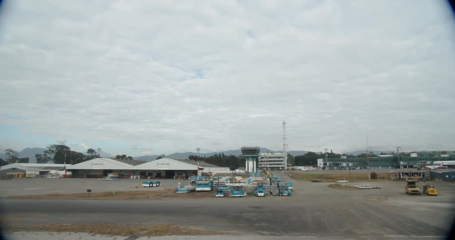 White clouds float over buildings and parking lots