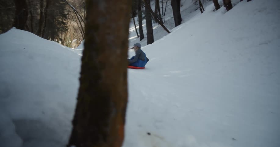 Woman slides down a snowy hill on a saucer