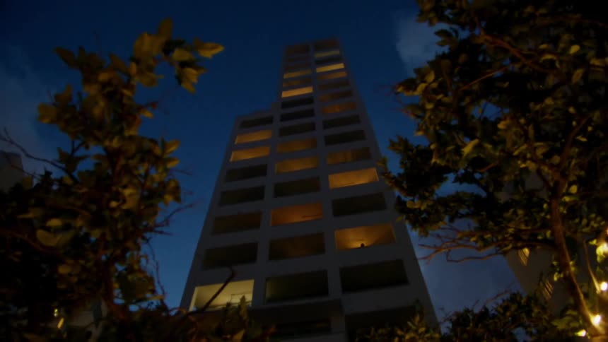 A tall building has floors completely lit with light