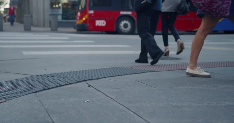People cross past the crosswalk in the street