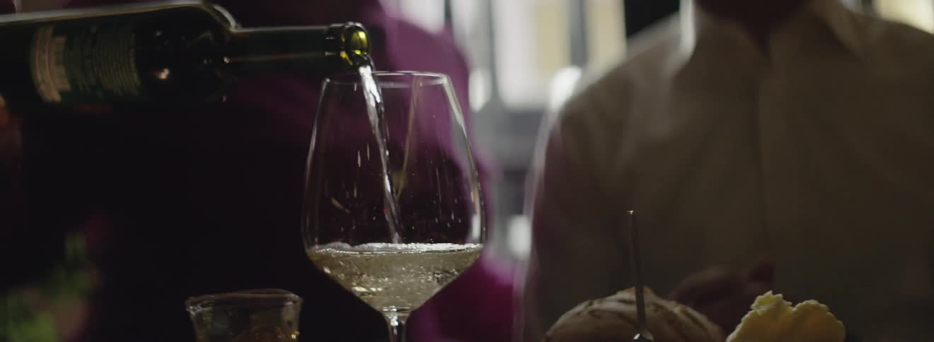 Man pours white wine into a glass