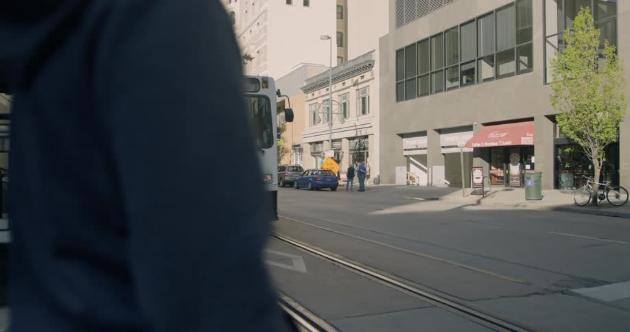 People cross the street as the trolley is stopped