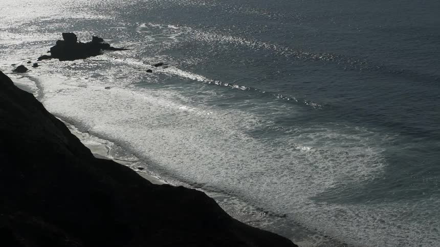 Foamy waves roll into shore at night