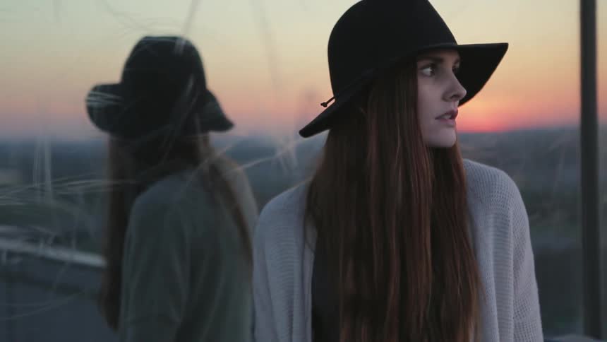 A woman is looking at the sunset