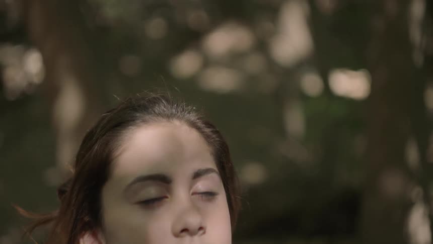 A woman is standing in the woods