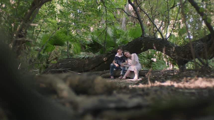 A couple watch the water in the stream