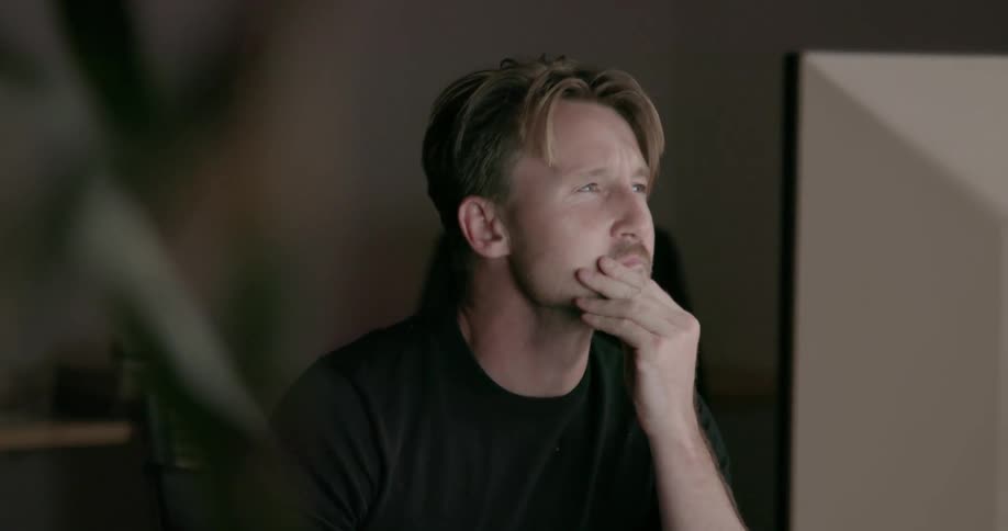 Man sits at desk thinking