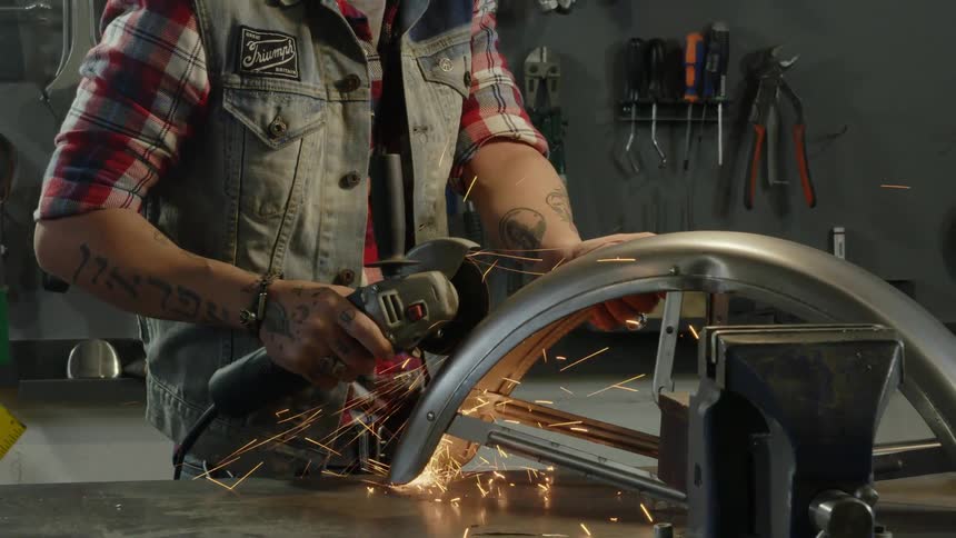 A man is using a tool to grind metal