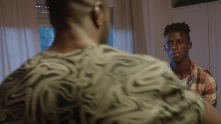 Two men smoke and dance in the apartment