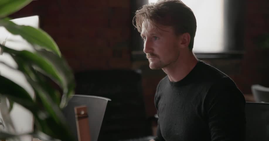 A man types on a keyboard in an office