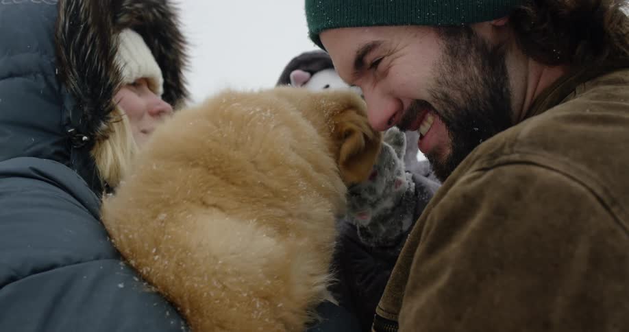 Parents and a young baby play outside in the snow