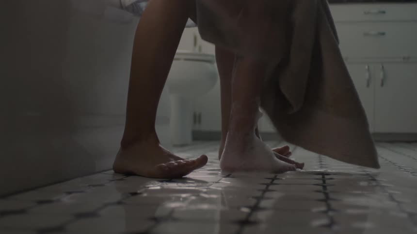 A child gets out of the bath and dries off