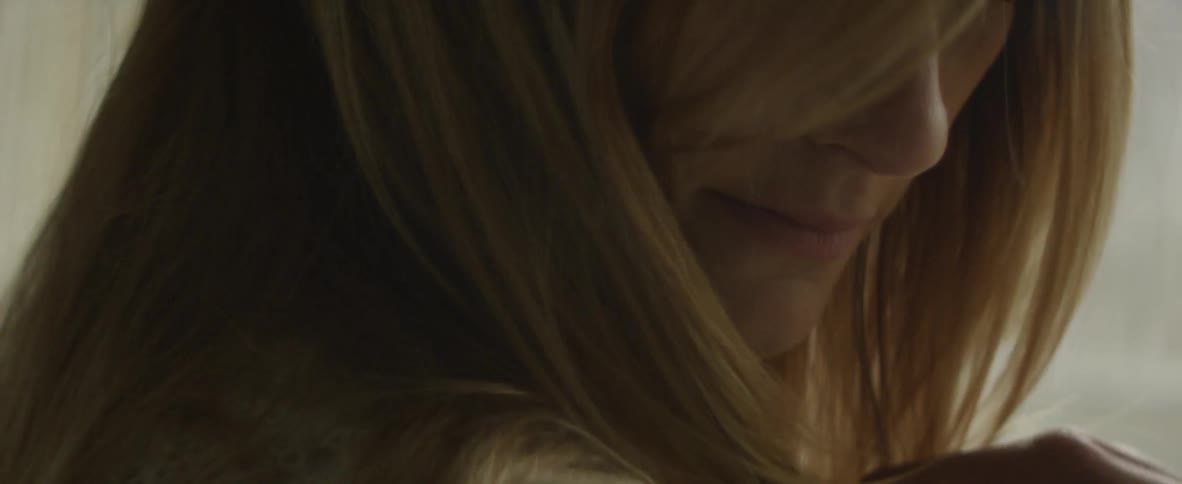 A woman nods her head down with hair covering her face