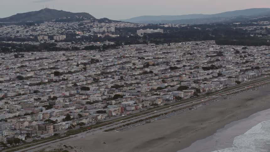 The cars drive past the road near the coastal town