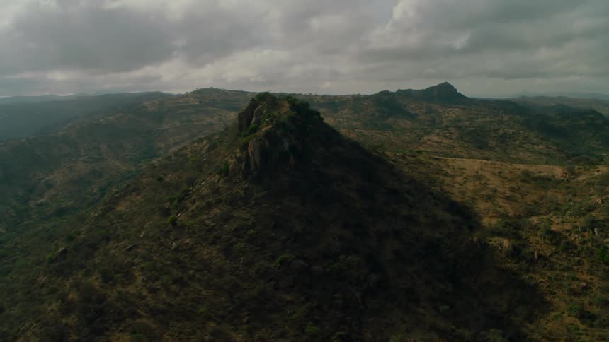 The hills are covered with green and heavy clouds