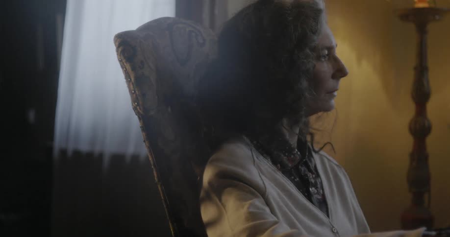 A woman rocking in a chair turns her head