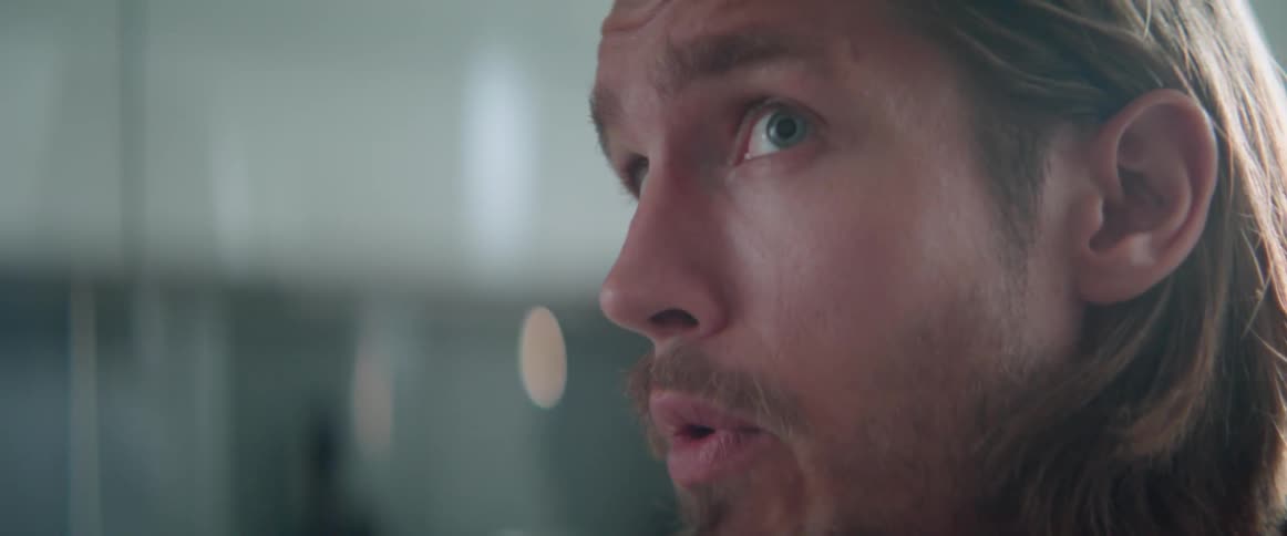 Extreme close up of a worried guy talking with someone during a dispute.