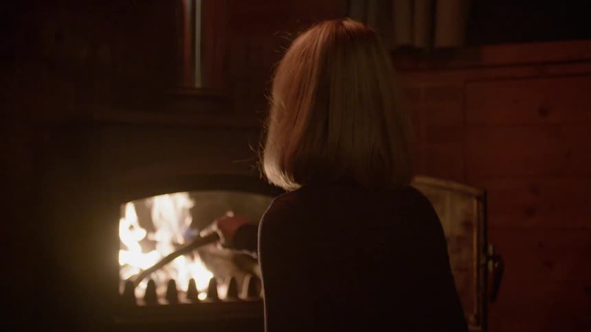 A woman stirs the fire in the oven