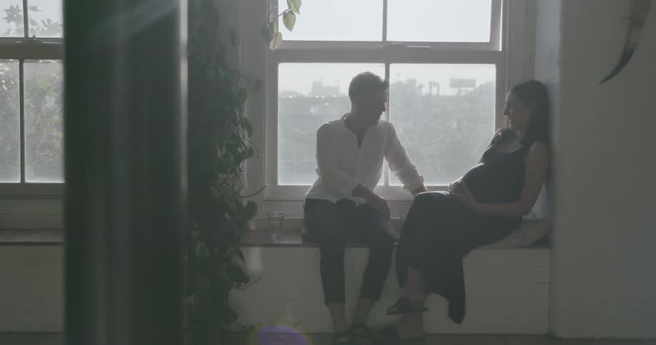 Man and woman sit in front of a window on a sunny day