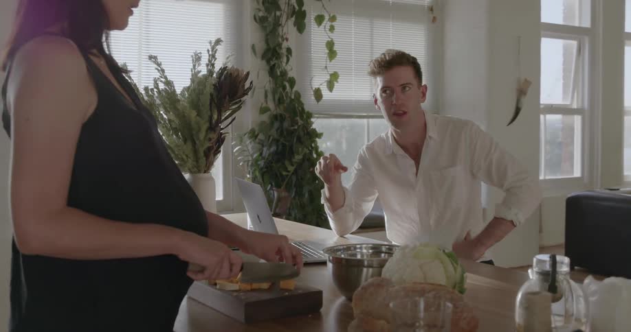A man and woman talk at the dining room table