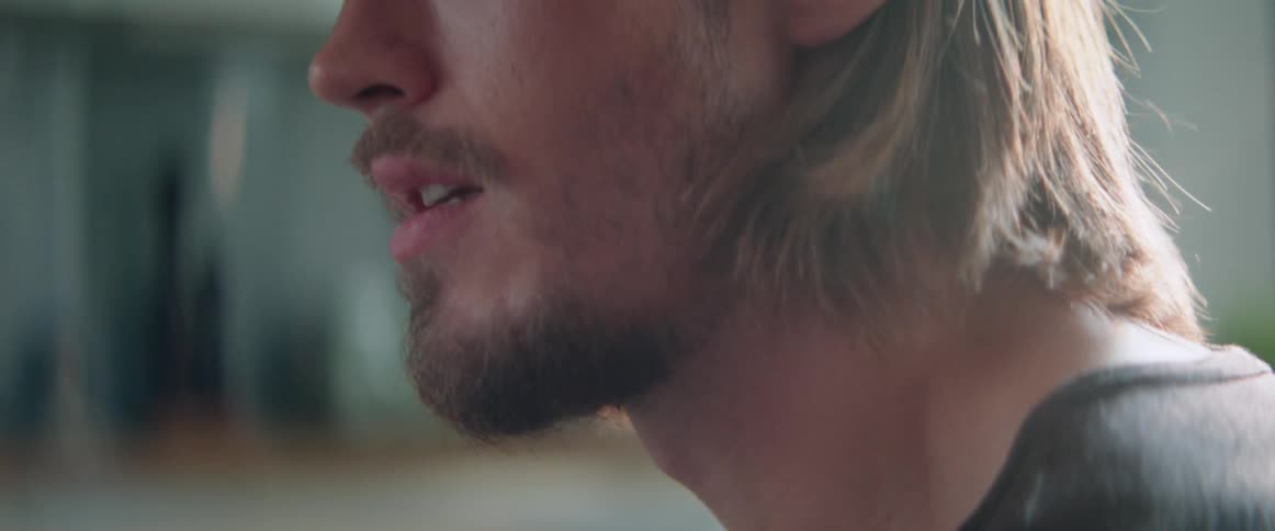Close up view of a bearded man speaking with a concerned facial expression.