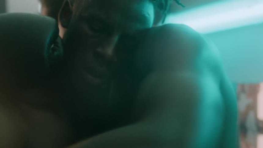 A boxer holds onto another man and consoles him after a fight