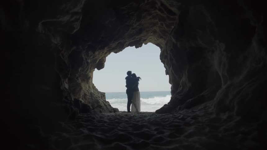 A man and woman hug on the beach