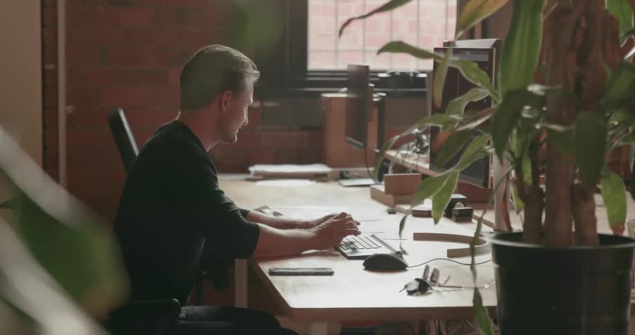 A man types at his computer in the office