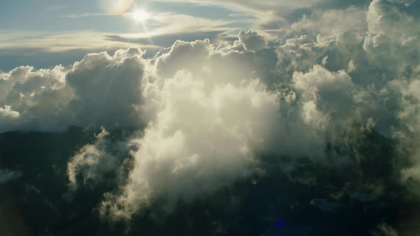 Sun shines over puffy white clouds