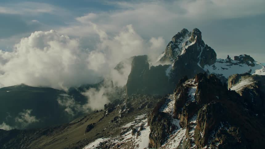 Clouds pass and hang above the stone mountains