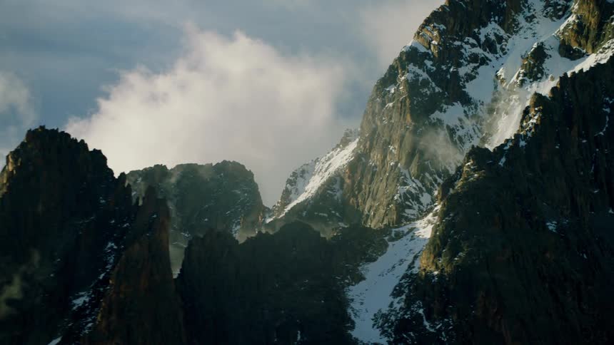 The clouds move over the tall mountain tops