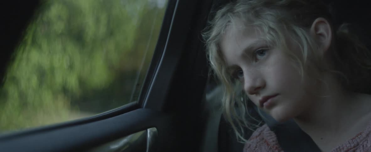 A teenage girl is looking bored during a car ride