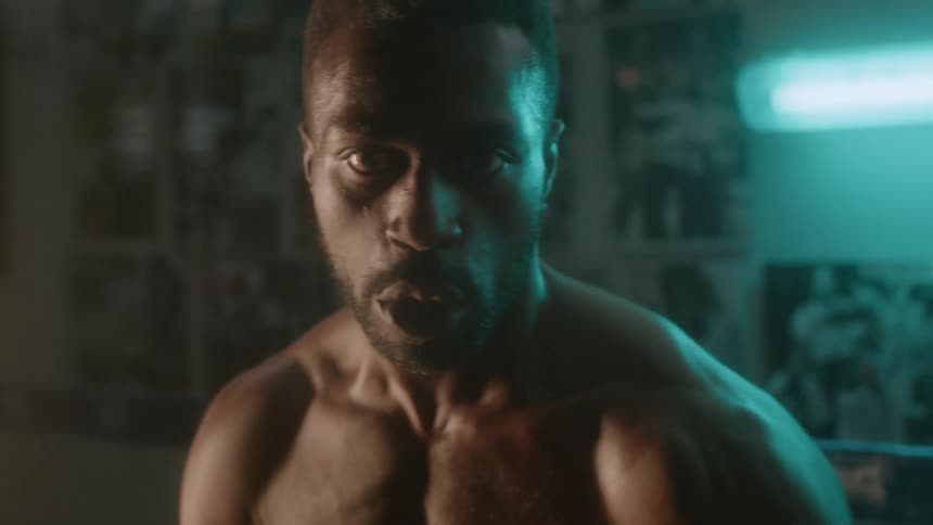 A man is boxing in the dark gym