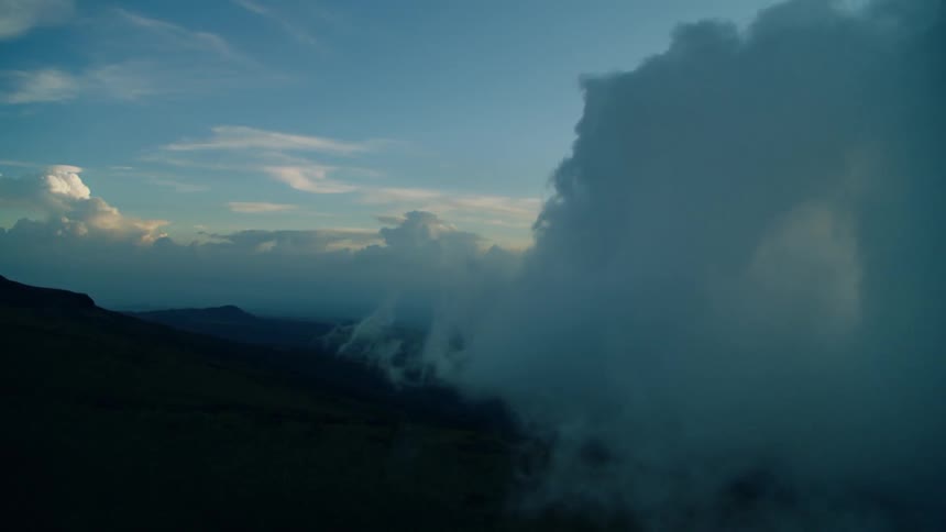The heavy clouds roll over the dark mountains