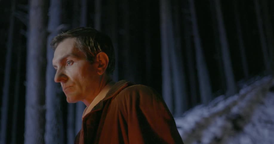 A man looks forward as lights flicker on him