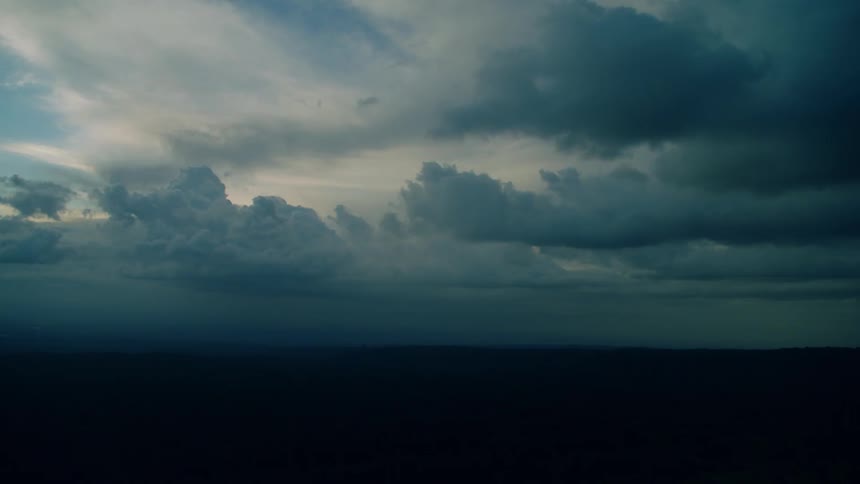 The sun sets behind the thick clouds overhead