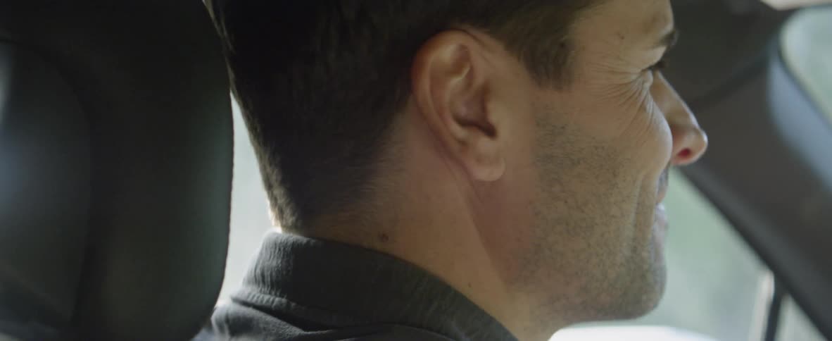 A man in the driver's seat turns his head