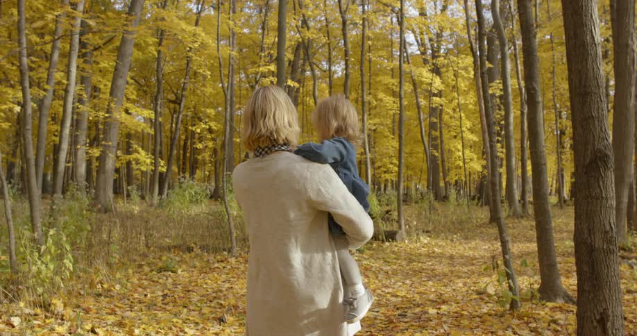 A woman and her daughter are walking through the woods