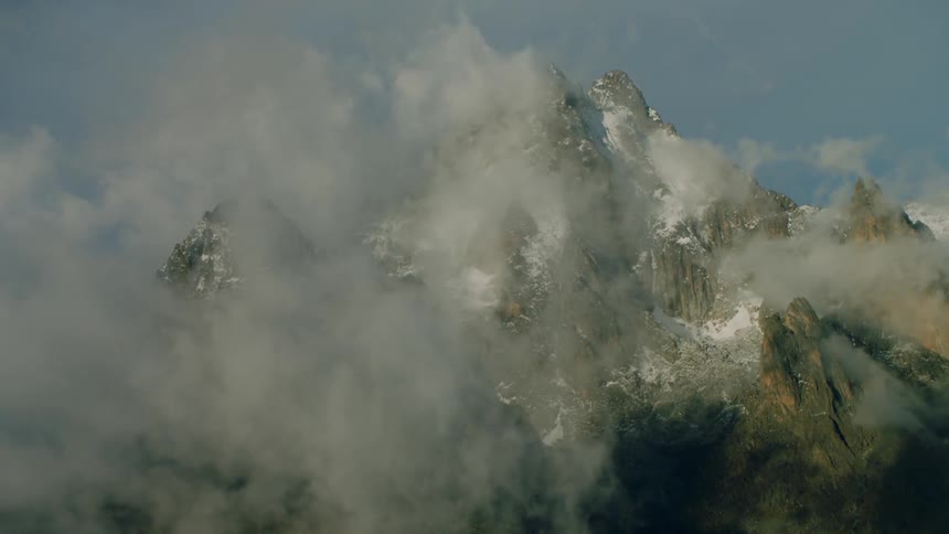 A tall mountain sticking out through the clouds