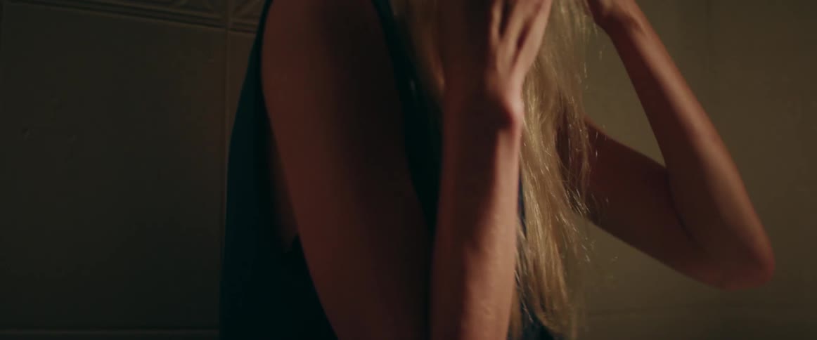 A frustrated female holds a mobile phone to her ear during tense conversation.