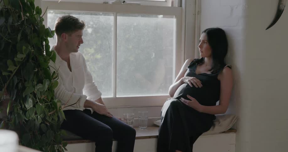 A man and woman sit by the window chatting