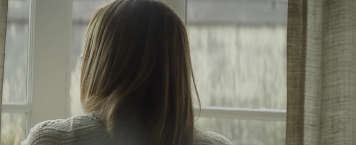 A woman exits through the glass door