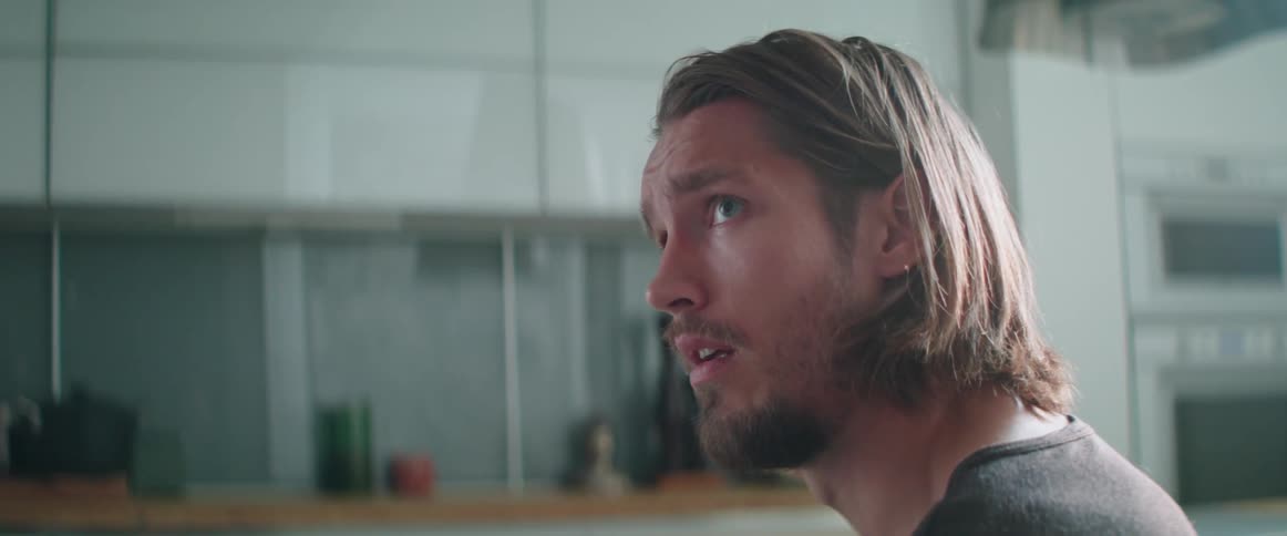 A worried guy looks up with a sad expression while talking at home.