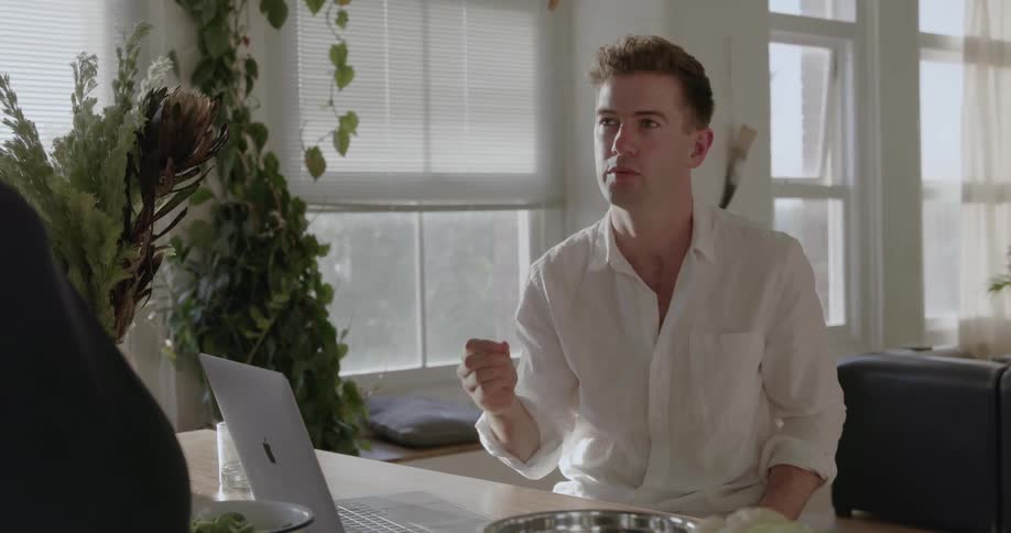 A man sits at the table talking with someone