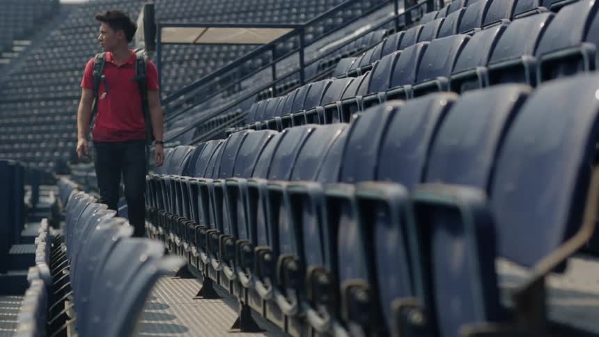 A man sits down in an empty stadium